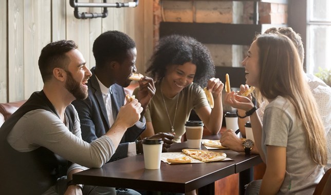 Friend eating pizza and smiling