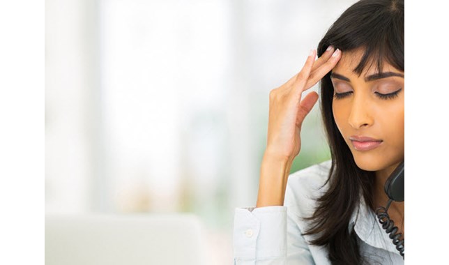 Girl talking on a phone and holding her head