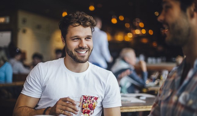 Man smiling and drinking water