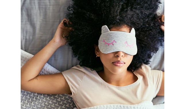 Woman sleeping in the bed with sleeping mask